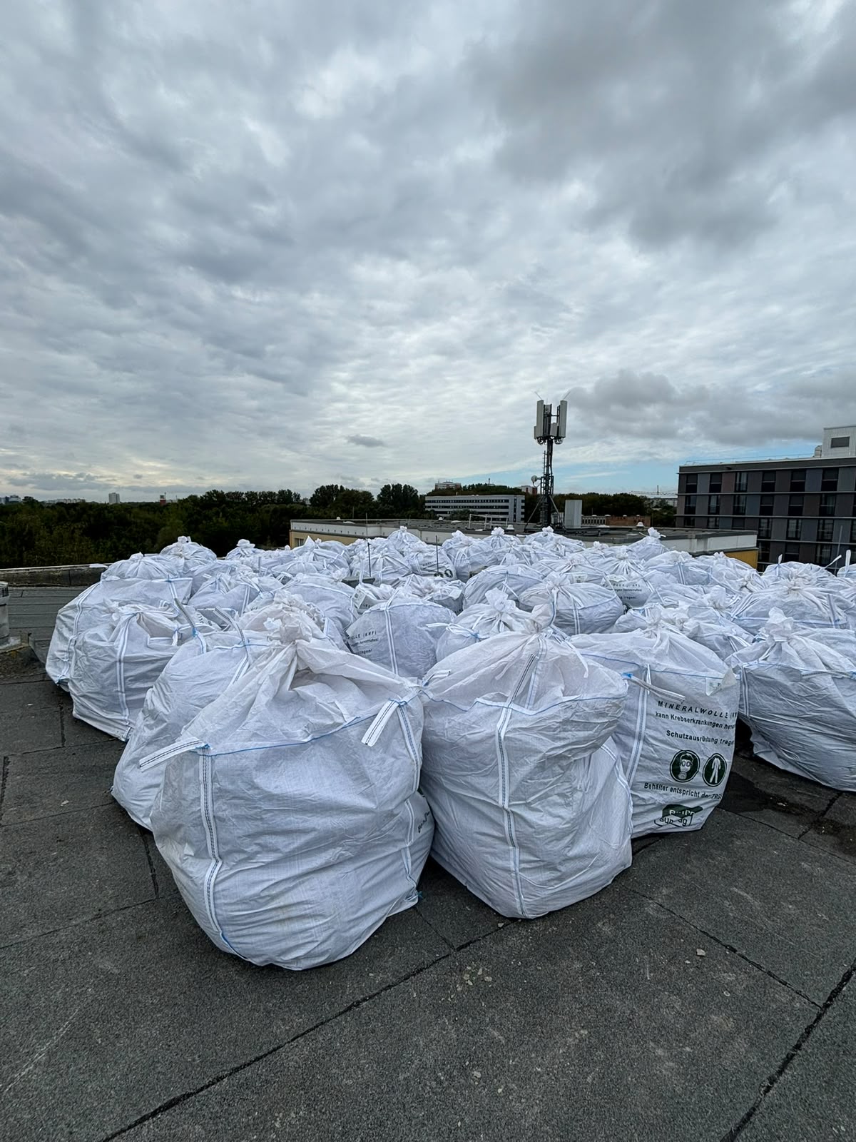 Staubdicht verpackte Mineralwolle in gekennzeichneten Big Bags auf einem Flachdach