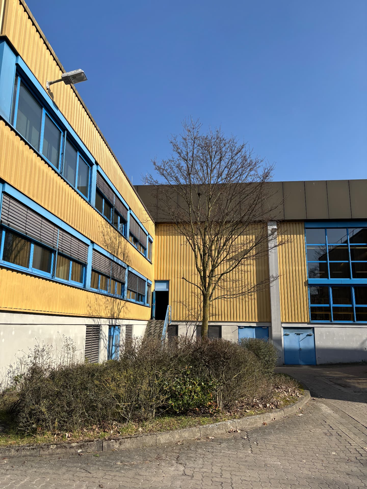Industrieanlage mit Trapezblechfassade und blauen Fensterrahmen — Standort Hannover